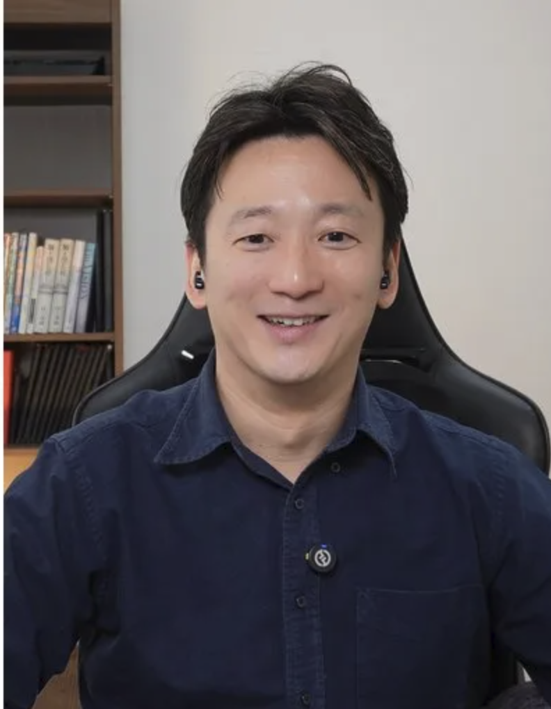 正面を向いて自然に笑うAloha English英会話の日本人トレーナー・松本兼頌。紺色のシャツ姿。